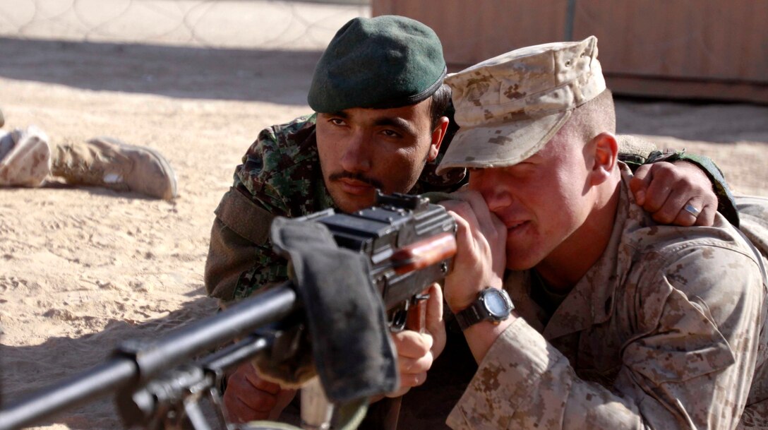 Mohammad Zaman, a soldier with the Afghan National Army’s 5th Kandak, 1st Brigade, 215th Corps, serves as a spotter as Cpl. Phillip Sever, 20, Headquarters & Service Company mentor, Embedded Partnering Team, Combat Logistics Battalion 3, 1st Marine Logistics Group (Forward), sights in during a weapons class on Camp Leatherneck, Afghanistan, Nov. 21. The 20 Marines and sailors with CLB-3’s EPT are mentoring and training the soldiers of 5/1/215 – an ANA logistics battalion – so they can operate independently.