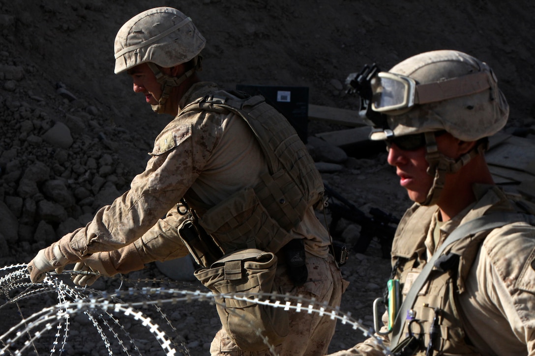 Marines with Charlie Company, Combat Logistics Battalion 2, 1st Marine Logistics Group (Forward), set up concertina wire at Forward Operating Base Robinson in Sangin, Afghanistan, Nov. 19. The engineers completed force protection improvements to the small base, enhancing security for Marines who operate from the FOB.