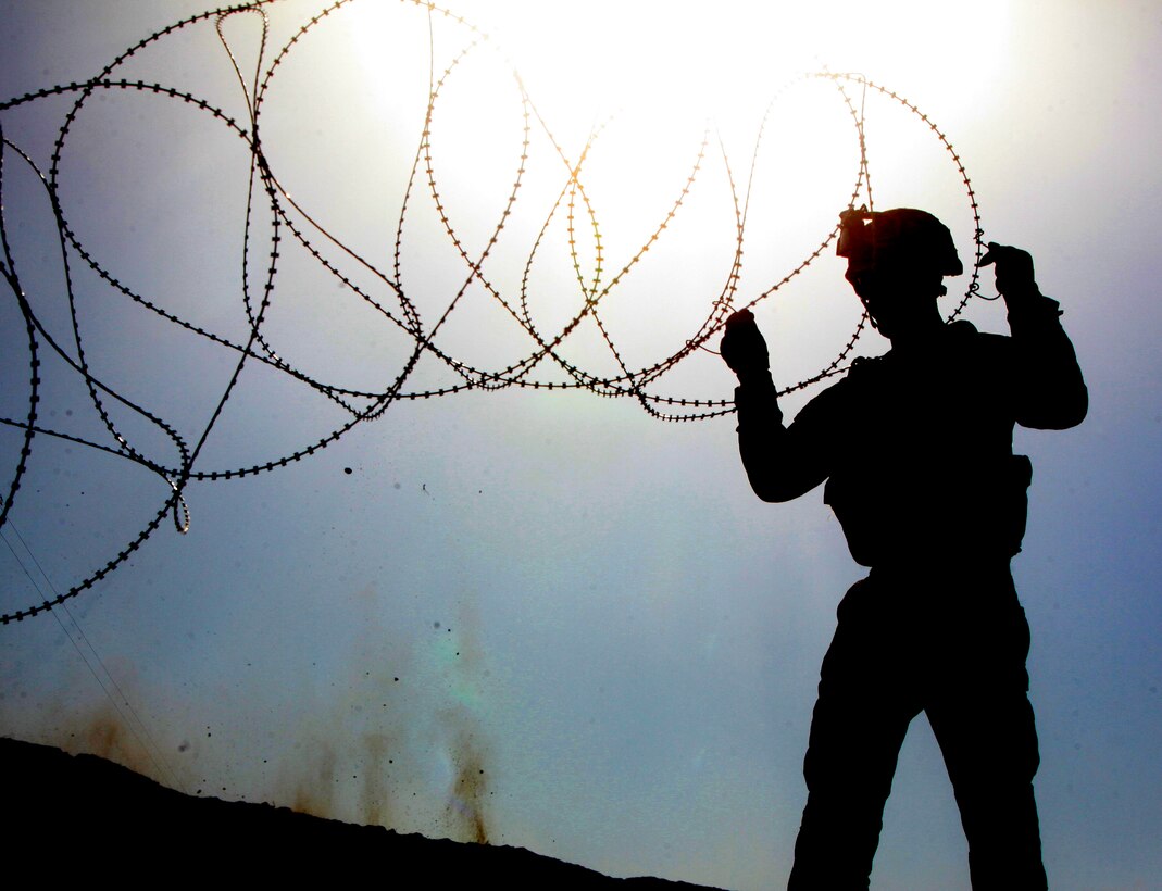 Lance Cpl. Christopher Piotter, an engineer with Charlie Company, Combat Logistics Battalion 2, 1st Marine Logistics Group (Forward) sets up concertina wire at Forward Operating Base Robinson in Sangin, Afghanistan, Nov. 19. The engineers completed force protection improvements to the small base, enhancing security for Marines who operate from the FOB.