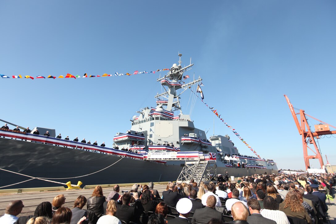 Thousands of service members, families and friends sit together in observance of the commissioning ceremony of the USS Gravely at the State Ports in Wilmington, N.C., Nov. 20. The ceremony was not only in celebration of the Navy’s newest destroyers, it was a tribute to the late Vice Adm. Samuel Lee Gravely Jr., who was an African-American pioneer, and his family.