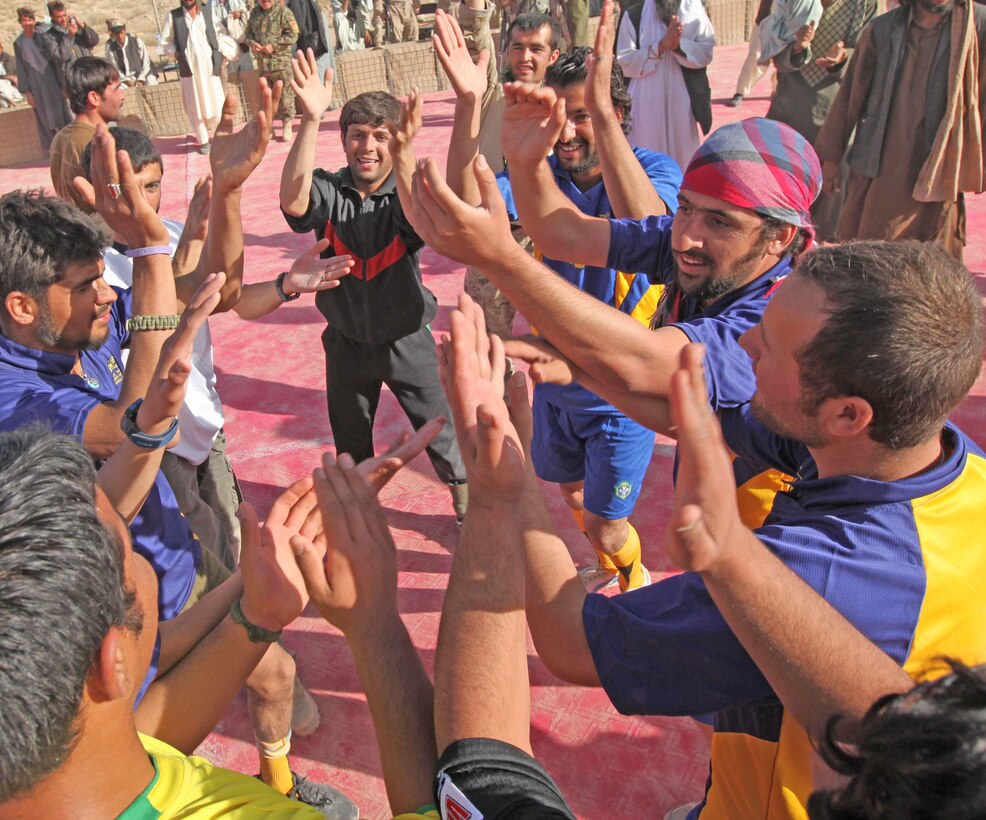 ANA soldiers and interpreters dance to live music during half-time at an Eid celebratory soccer tournament at Marine Corps Forward Operations Base Camp Hansen, Nov. 20. Marines, Afghanistan National Army soldiers, Interpreters and local nationals all competed during the event. The crowd enjoyed live music, fresh fruit and gifts, such as soccer balls and sports jerseys.