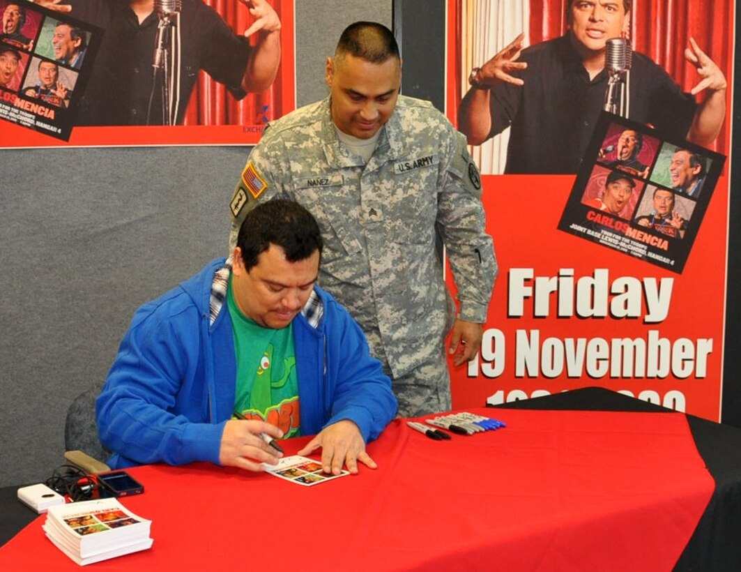JOINT BASE LEWIS MCCHORD, Wash.- Actor and comedian, Carlos Mencia, of Comedy Central's "Mind of Mencia", signs an autograph for a Soldier during his meet and greet for troops session at the Lewis-Main Post Exchange, Nov. 19. This was just one stop for his "Tour for the Troops" before giving a stand-up performance at McChord Field. Mencia also got to experience flying a C-17 Globemaster III in flight simulator at McChord Field. (U.S. Air Force photo/Master Sgt. Jake Chappelle) 