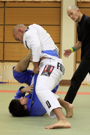 Chief Warrant Officer Sergio Esquivel, bluebelt in Jujitsu and second degree blackbelt in the Marine Corps Martial Arts Program, competes against Fujioka Yu, blue-belt competitor, during the 8th Annual West Japan Jujitsu Championship tournament at the Minami Ward Sports Center in Hiroshima::r::::n::Sunday. The Minami Ward Sports Center in Hiroshima hosts many martial arts competitions, which are open to all competitive skill levels and techniques within the rules of the sport.