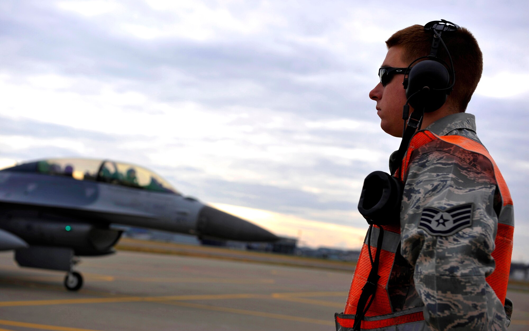 U.S. Air Force Staff Sgt. Jamie Drooger, 35th Aircraft Maintenance Squadron end-of-runway NCO in charge, marshals six F-16 Fighting Falcons during the EOR inspection at Misawa Air Base, Japan, Nov. 19, 2010. The purpose of an EOR inspection is to arm the munitions on the jet. (U.S. Air Force photo by Staff Sgt. Chad C. Strohmeyer/Released)