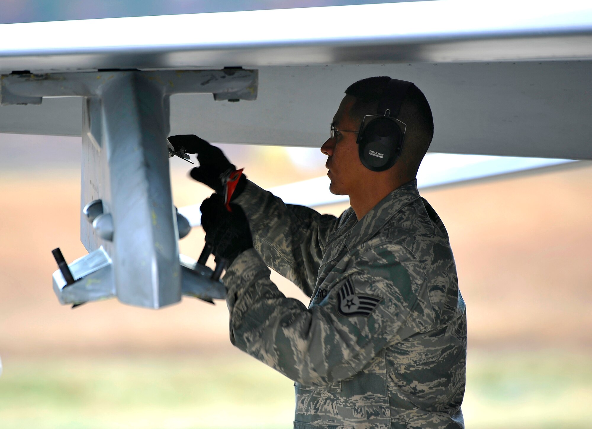 U.S. Air Force Staff Sgt. Steven Ayala, 35th Maintenance Operations Squadron weapons loader, stores pins in the weapons pylon on an F-16 Fighting Falcon during the end-of-runway inspections at Misawa Air Base, Japan, Nov. 19, 2010. EOR Airmen check the entire aircraft for structural defects, or problems as it pulls up to the EOR, and engages any weapons it may be armed with. (U.S. Air Force photo by Staff Sgt. Chad C. Strohmeyer/Released)