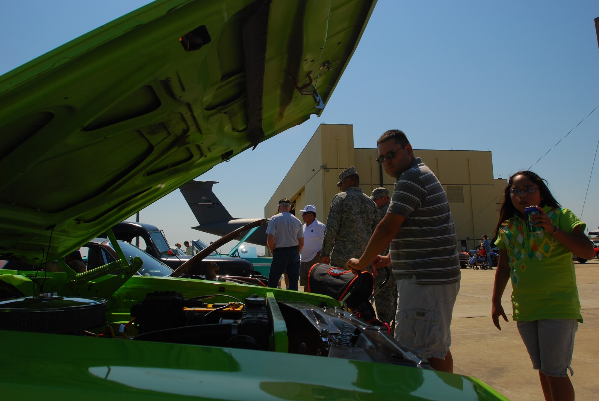 Staff Sgt. Ernest McDonald and his daughter Caitlyn stop to look at a Dodge Charger during the car show of the 433rd Airlift Wing Family Day. In addition to the car show, the family day had games for children, military drill exercises and a C-5A Galaxy II cargo aircraft. (U.S. Air Force photo/Airman 1st Class Brian McGloin)