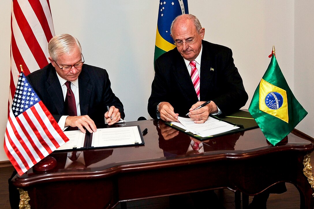 U.S. Defense Secretary Robert M. Gates and Brazilian Defense MInister Nelson Jobim sign a Security of Military Information Agreement during a bilateral meeting in Santa Cruz, Bolivia, Nov. 21, 2010. Gates and Jobim are in Bolivia to attend a conference for Western Hemisphere defense ministers.