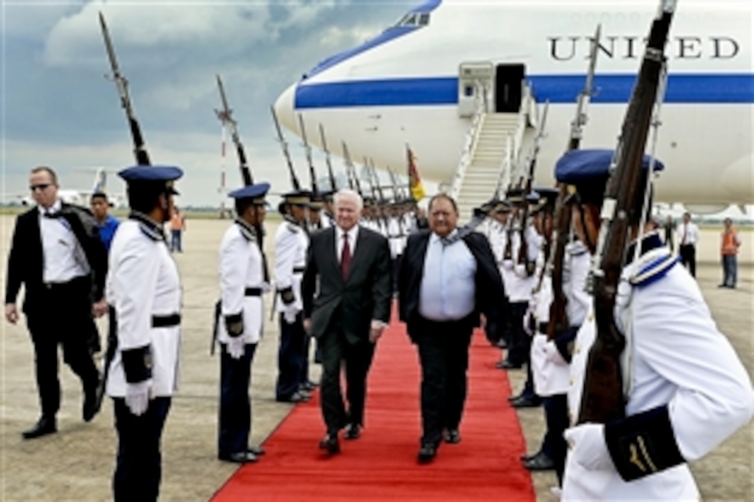 U.S. Defense Secretary Robert M. Gates walks with Bolivian Ambassador Fernando Huanacuni and receives full military honors as he arrives in Santa Cruz, Bolivia, Nov. 21, 2010. Gates is in Bolivia to attend a conference of Western Hemisphere defense ministers.