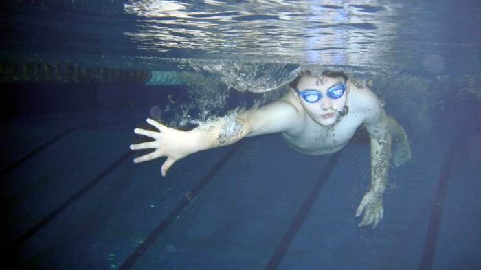 William Rudolph, 9, Iwakuni Tsunami swim team member, swims toward the finish during a swim meet between the Iwakuni Tsunami swim team and the Sasebo Riptides at the IronWorks Gym here Nov. 20. Rudolph placed third with a time of 1:06.59 in the 50-meter backstroke during the competition. First, second and third place medals were awarded to winners of each race. An additional medal was awarded to each participant.