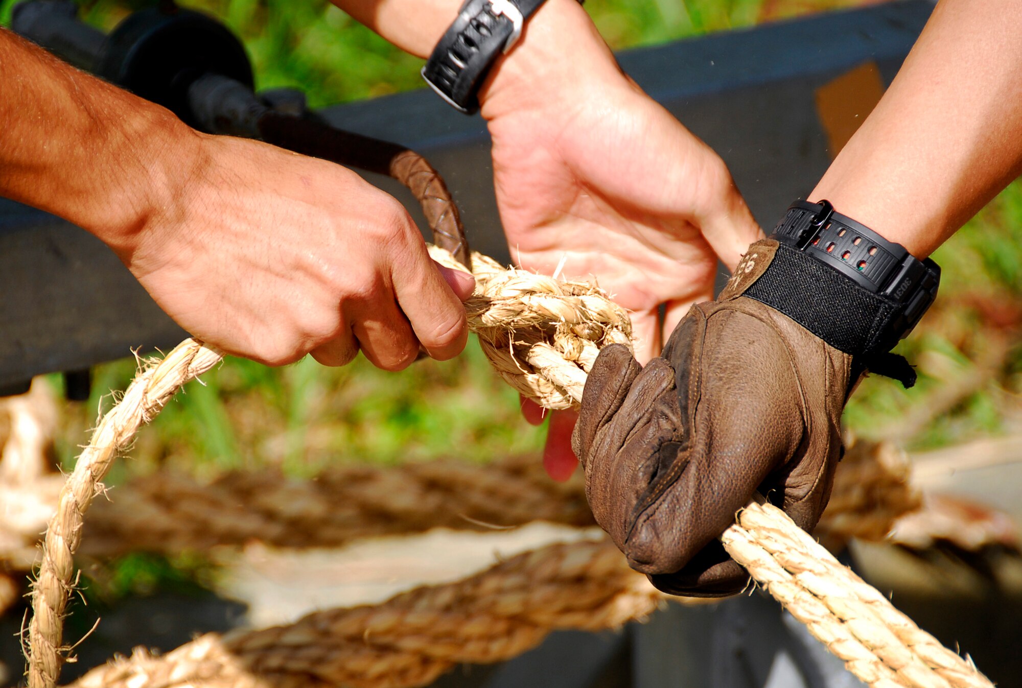 Volunteers from Kadena and Okinawa City work together Nov. 21 to hitch several ropes to a crank that will then be used to twist them together, forming a larger rope. The larger rope is then combined with hundreds more to form a mammoth, four-ton, football field-length rope to be used in the giant tug-of-war at the Okinawa City International Carnival on Okinawa City’s “Koza Gate Street,” just outside Kadena’s Gate 2 Nov. 27. (U.S. Air Force photo/ Airman 1st Class Maeson L. Elleman)