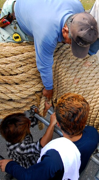 A group of volunteers from Kadena Air Base and Okinawa City band together hand-made rope Nov. 21 to form an even more enormous rope for the Okinawa City International Carnival’s giant tug-of-war on Okinawa City’s “Koza Gate Street,” just outside Kadena’s Gate 2 scheduled Nov. 27. The rope is made of two halves – a male and female – each weighing nearly two tons and when combined, span longer than a football field. (U.S. Air Force photo/ Airman 1st Class Maeson L. Elleman)