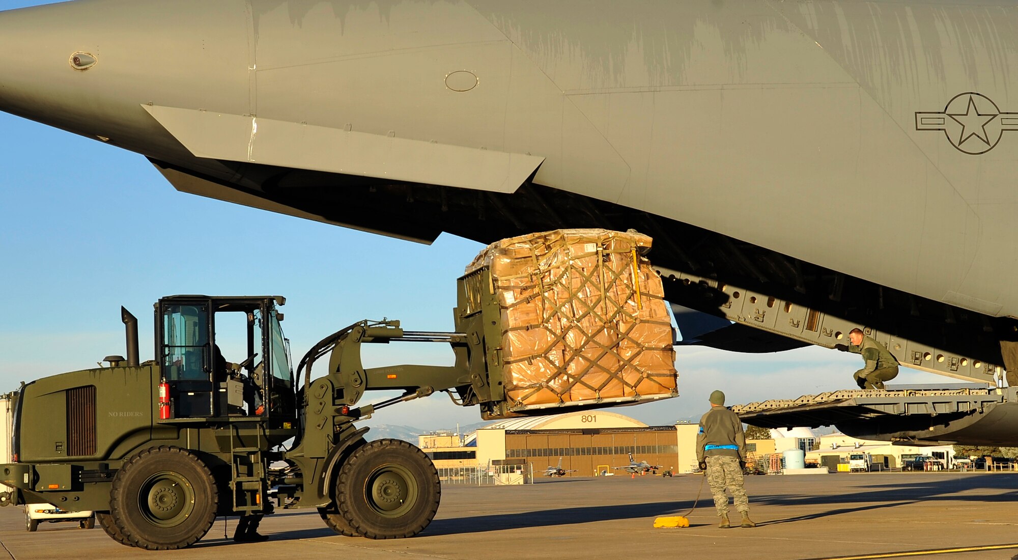 A C-17 Globe Master III sits on a runway while being loaded with pallets containing supplies, Nov. 22, 2010. The supplies will allow for the refurbishing and/or rebuilding of 25 hospitals and clinics in the region.(U.S. Air Force photo by Airman 1st Class Paul Labbe.)
