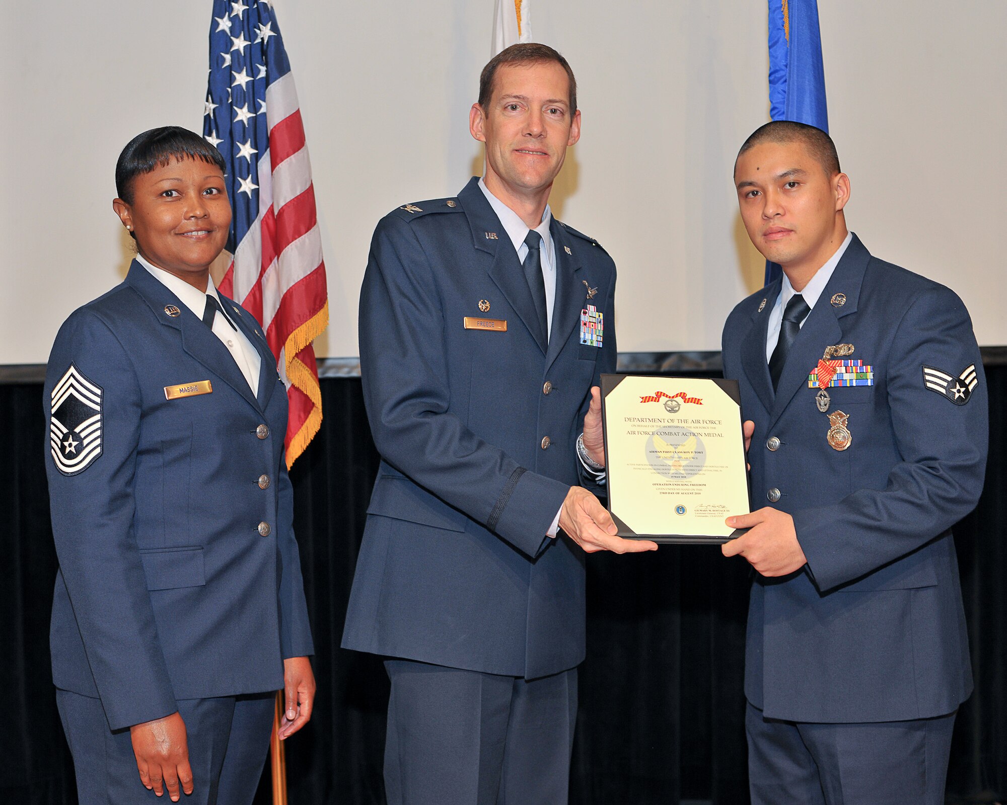 YOKOTA AIR BASE, Japan -- Col. Todd Freece, 374th Force Support Group commander, presents Senior Airman Roy Tort, 374th Security Forces Squadron, the Air Force combat action medal here Nov. 23 in recognition of his support for Operation ENDURING FREEDOM. (U.S. Air Force photo/Osakabe Yasuo)