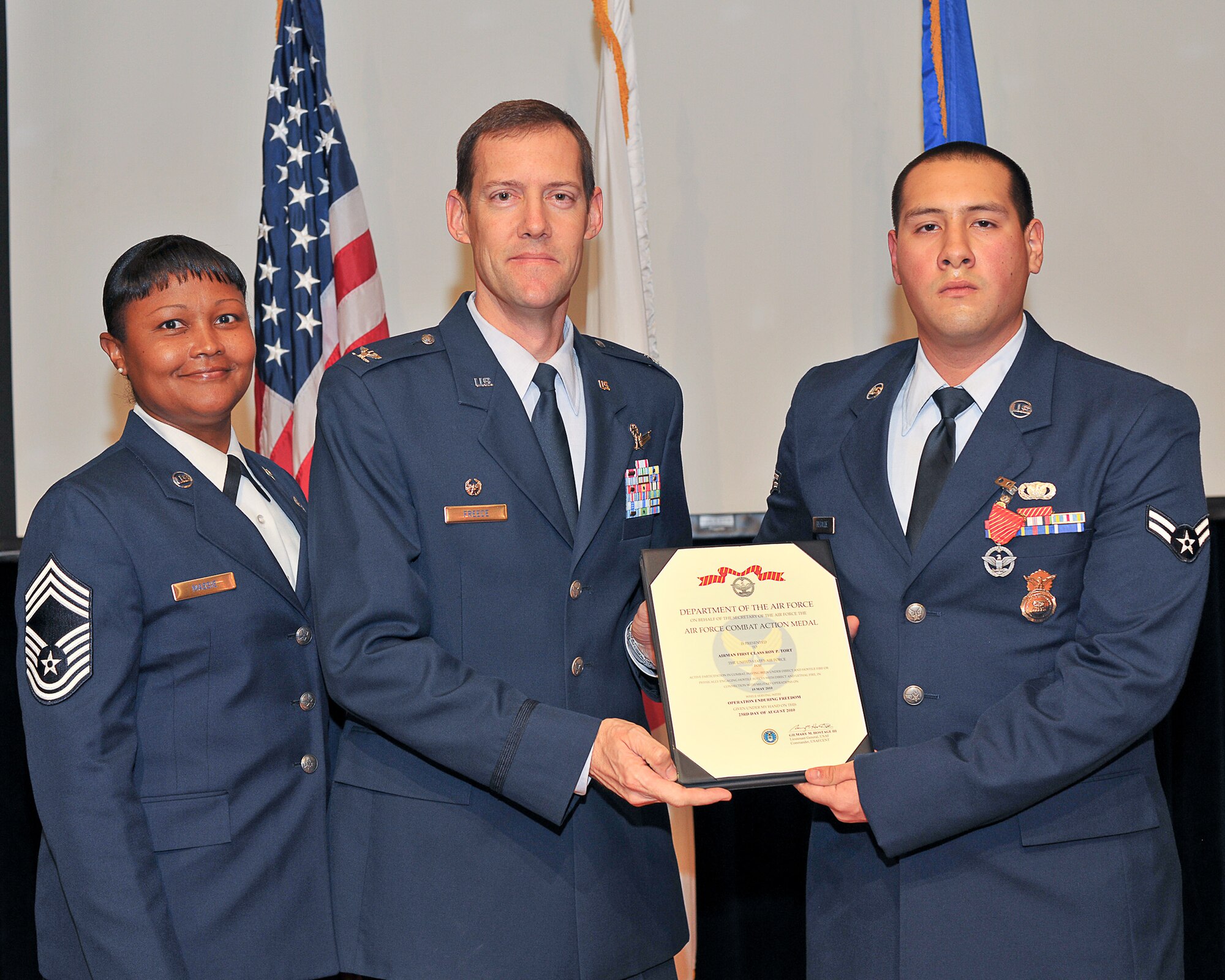 YOKOTA AIR BASE, Japan -- Col. Todd Freece, 374th Force Support Group commander, presents Airman 1st Class Joseph Recalde, 374th Security Forces Squadron, the Air Force combat action medal here Nov. 23 in recognition of his support of Operation ENDURING FREEDOM. (U.S. Air Force photo/Osakabe Yasuo)