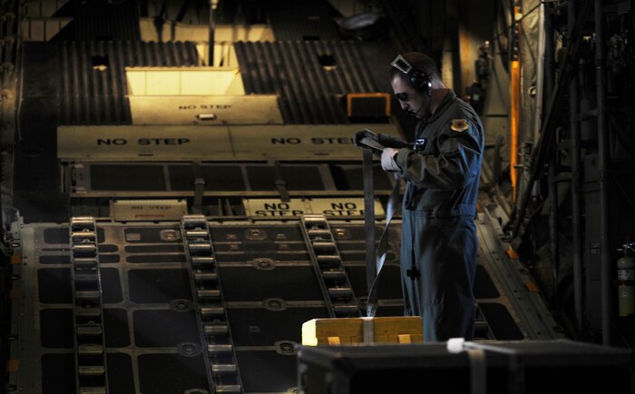 NELLIS AIR FORCE BASE, Nev.-- Staff Sgt. Grant Lane, 29th Weapons Squadron, Little Rock Air Force Base, Ark., straps down a cargo box Nov. 17 at Nellis during a Mobility Air Forces Exercise. More than 40 C-17 Globemaster III and C-130 Hercules cargo aircraft assembled in aerial formations over the Nevada Test and Training Range to conduct air and ground operations as part of the bi-annual U.S. Air Force Weapons School MAFEX. (U.S. Air Force photo/ Master Sgt. Kevin J. Gruenwald)