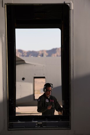 NELLIS AIR FORCE BASE, Nev.--  Senior Airman Tony Taylor, a flying crew chief with the 317th Aircraft Maintenace Squadron, Dyess Air Force Base, Texas, checks around a C-130 Hercules during the Mobility Air Forces Exercise Nov 17. More than 40 C-17 Globemaster III and C-130 Hercules cargo aircraft assembled in aerial formations over the Nevada Test and Training Range to conduct air and ground operations as part of the bi-annual U.S. Air Force Weapons School MAFEX. (U.S. Air Force photo by Senior Airman Brett Clashman)