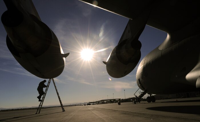 NELLIS AIR FORCE BASE, Nev.-- Tech. Sgt. Zachariah Pock, a crew chief with the 62nd Aircraft Maintenance Squadron, McChord Air Force Base, Wash., climbs a ladder to check the engine intakes of a C-17 Globemaster III during a Mobility Air Forces Exercise Nov 17. More than 40 C-17 Globemaster III and C-130 Hercules cargo aircraft assembled in aerial formations over the Nevada Test and Training Range to conduct air and ground operations as part of the bi-annual U.S. Air Force Weapons School MAFEX. (U.S. Air Force photo by Senior Airman Brett Clashman)