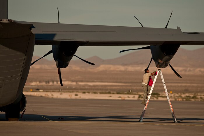 NELLIS AIR FORCE BASE, Nev. --   A C-130 Hercules Crew Chief with the 19th Maintenance Group, Little Rock Air Force Base, Ark. uses a ladder to conduct post flight checks of the C-130 Hercules engine intakes on the Nellis flightline during the Mobility Air Forces Exercise held at the Nevada Test and Training Range,  Nov 17. Approximately 40 C-17 Globemaster and C-130 Hercules cargo aircraft will assemble in aerial formations over the NTTR to conduct air and ground operations as part of the bi-annual, U.S. Air Force Weapons School Mobility Air Forces Exercise.  (U.S. Air Force photo by Tech. Sgt. Michael R. Holzworth)(Released)