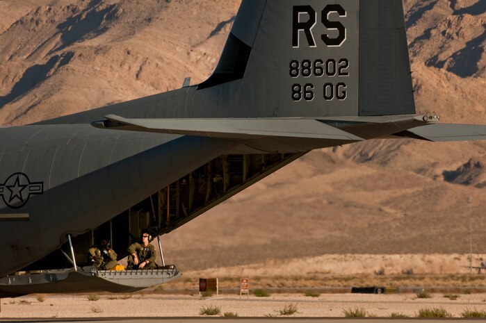 NELLIS AIR FORCE BASE, Nev.--  Loadmasters from the 86th Airlift Wing, Ramstein Air Base, Germany, sit on the open ramp of a C-130 Hercules as it taxis down the Nellis flightline during a Mobility Air Forces Exercise Nov 17. More than 40 C-17 Globemaster III and C-130 Hercules cargo aircraft assembled in aerial formations over the Nevada Test and Training Range to conduct air and ground operations as part of the bi-annual U.S. Air Force Weapons School MAFEX. (U.S. Air Force photo by Tech. Sgt. Michael R. Holzworth)