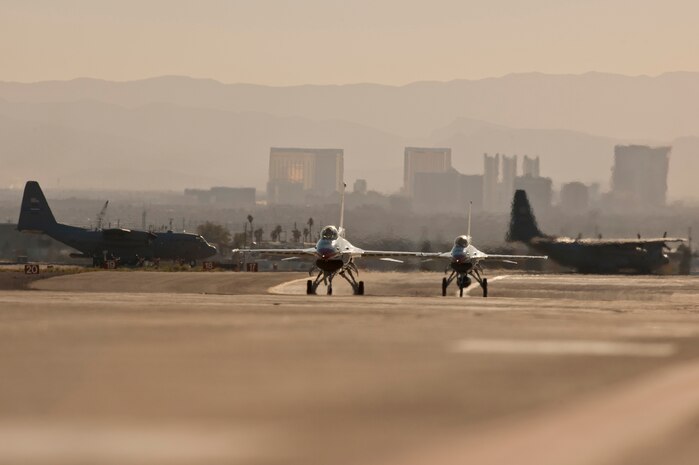 NELLIS AIR FORCE BASE, Nev. --  Two U.S. Air Force Air Demonstration Squadron "Thunderbirds" F-16's taxi down the runway while multiple C-130 Hercules aircraft taxi in after a Mobility Air Forces Exercise which was held at Nellis and the Nevada Test and Training Range,  Nov 17. Approximately 40 C-17 Globemaster and C-130 Hercules cargo aircraft will assemble in aerial formations over the NTTR to conduct air and ground operations as part of the bi-annual, U.S. Air Force Weapons School Mobility Air Forces Exercise.  (U.S. Air Force photo by Tech. Sgt. Michael R. Holzworth)(Released)