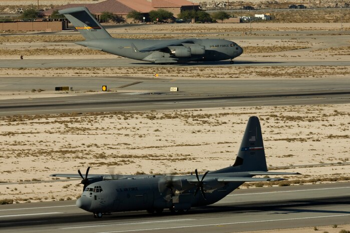 NELLIS AIR FORCE BASE, Nev.--  A C-17 Globemaster III aircraft prepares for takeoff on the Nellis taxiway as a C-130 Hercules lands during the Mobility Air Forces Exercise Nov 17. More than 40 C-17 Globemaster III and C-130 Hercules cargo aircraft assembled in aerial formations over the Nevada Test and Training Range to conduct air and ground operations as part of the bi-annual U.S. Air Force Weapons School MAFEX. (U.S. Air Force photo by Airman 1st Class Jamie Nicley)
