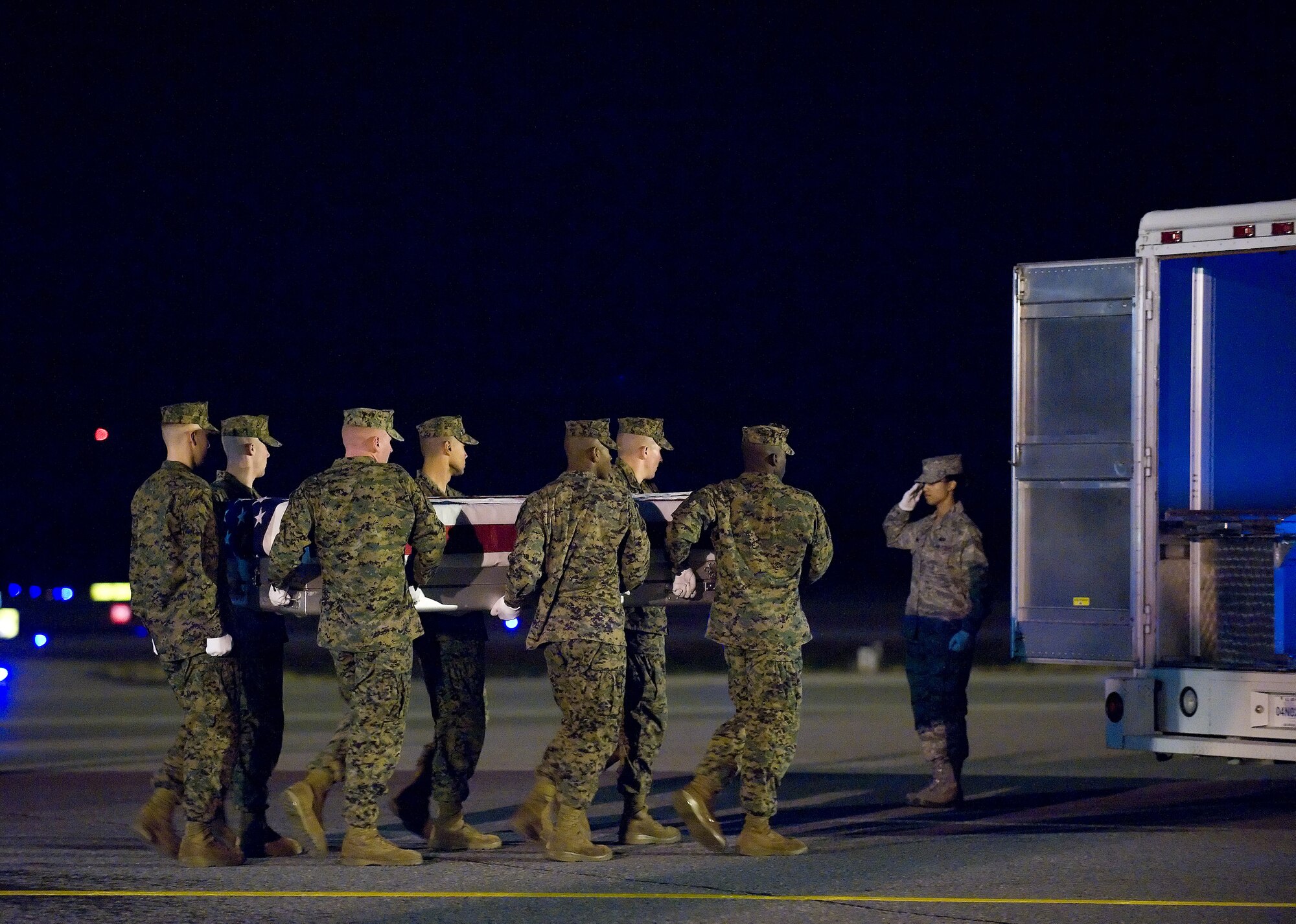 A U.S. Marine Corps carry team transfers the remains of Marine Sgt. Jason T. Smith of El Paso, Colo., at Dover Air Force Base, Del., Nov. 21, 2010.  He was assigned to the Explosive Ordnance Disposal Branch, Headquarters and Headquarters Squadron, Marine Corps Air Station Iwakuni, Marine Corps Bases Japan, Iwakuni, Japan. (U.S. Air Force photo/Jason Minto)
