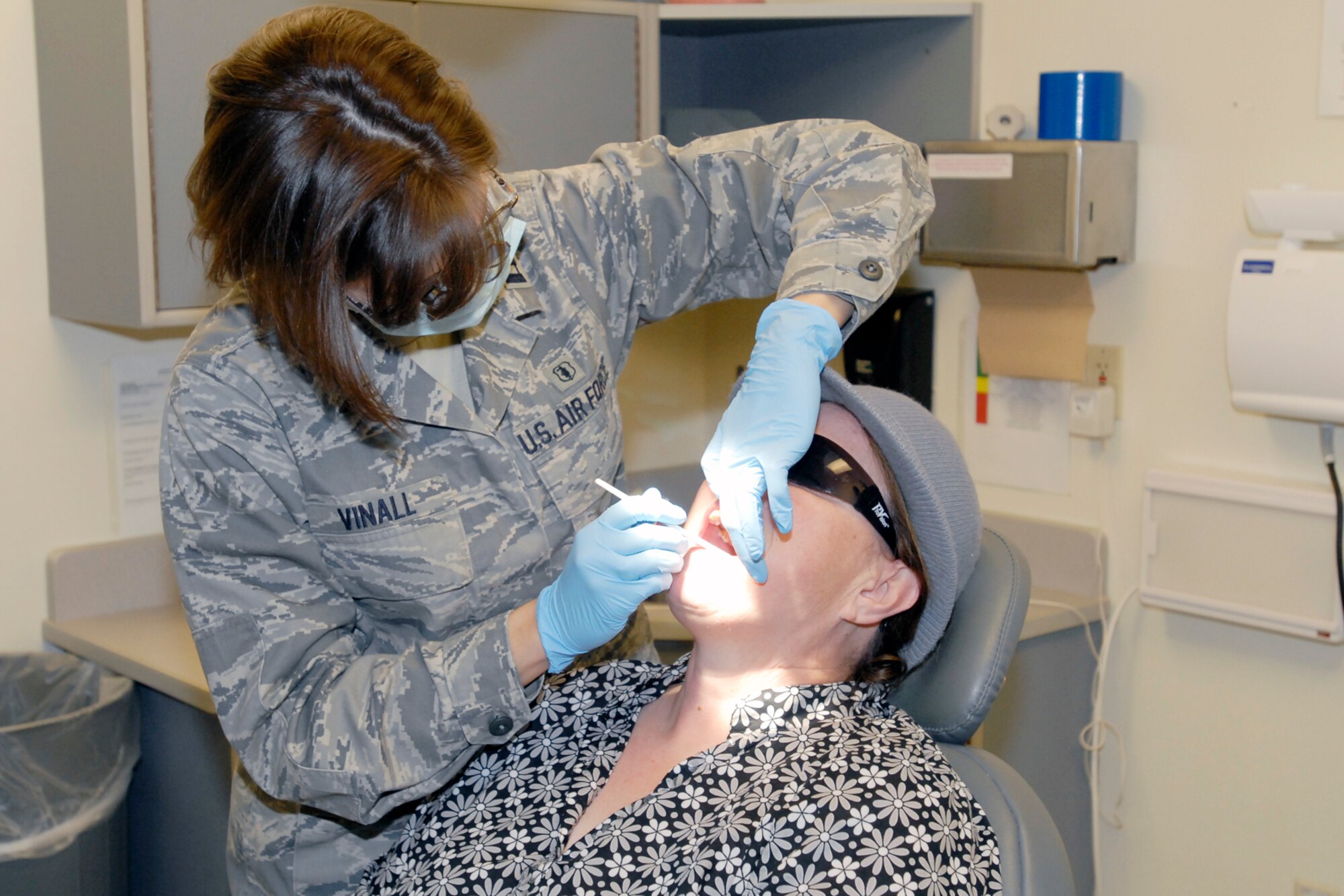 GOODFELLOW AIR FORCE BASE, Texas -- Karen Czarnecki, wife of retired U.S. Navy Petty Officer Lucian Czarnecki, receives an oral cancer screening from Capt. Abbey Vinall, 17th Medical Operations Squadron.   Oral screenings were just one of the services offered during the annual Retirees’ Health Fair at the Ross Clinic, Nov. 20. (U.S. Air Force Photo/Mr. Lou Czarnecki)