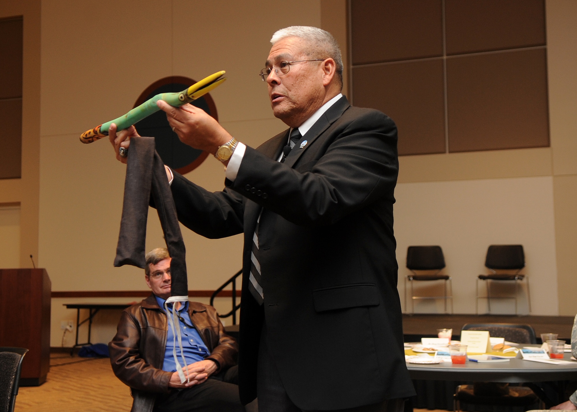 Buckley Air Force Base, Colo.-  Guest speaker, Chief Master Sergeant (Ret.) Bob Vasquez holds up a "talking stick" often used as a remedy to prevent interruptions during social gatherings.  ( U.S. Air Force Photo by Airman 1st Class Marcy Glass )
