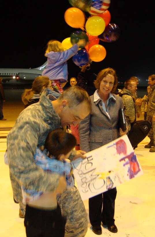Maj. R. Michael Mench, New Harmony officer in charge and commander of the Band of Flight, hugs his son Zachary upon returning Nov. 20, 2010, from a 120-day deployment in support of the U.S. Navy's Continuing Promise 2010. While traveling to Central and South America the 10-member ensemble played for about 48,000 people. (U.S. Air Force photo/Ron Fry)