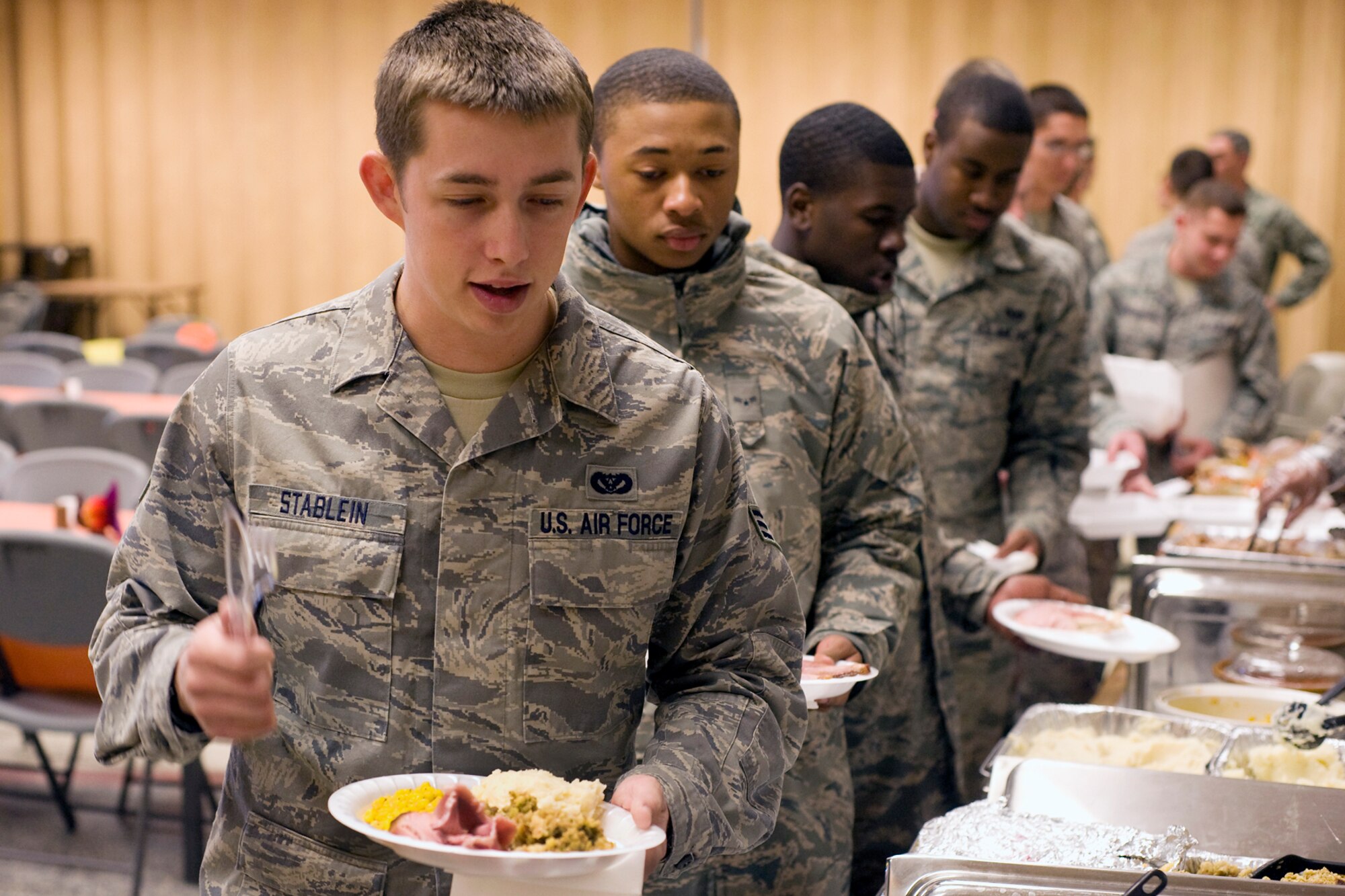 PETERSON AIR FORCE BASE, Colo. -- Senior Airman Jerry Stablein, 21st Civil Engineer Squadron, fills his plate Nov. 10 at the annual Thanksgiving Dorm Feast, hosted by the First Sergeants Association, at the Peterson AFB chapel. The feast was for unaccompanied Airmen E-4 and below. Col. Stephen N. Whiting, 21st Space Wing commander, and Chief Master Sgt. Robert Sealey, 21 SW command chief, attended the dinner to meet and talk with Airmen. (U.S. Air Force photo/Larry Hulst)