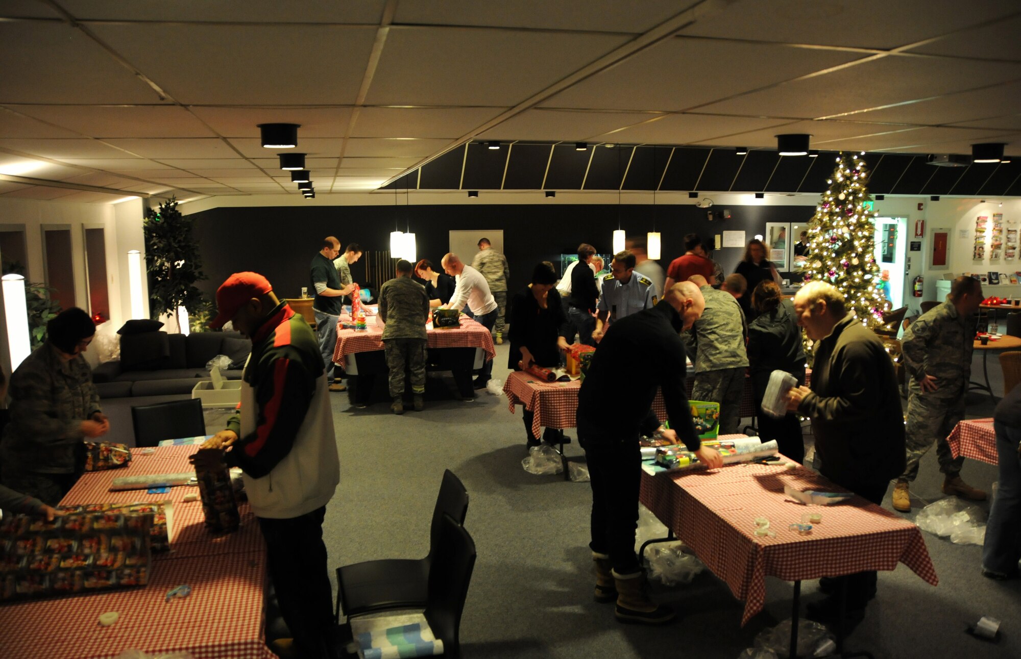 THULE AIR BASE, Greenland – Members of the 821st Air Base Group wrap dozens of presents to be given to children of Qaanaaq, the nearest village to Thule Air Base. As the northernmost air base in the world, just 946 miles from the North Pole, the wrapping party was also part of the group’s annual tradition of lighting a Christmas tree to ring in the holiday season. The 24 hours of darkness, which began Nov. 21, will not darken moods this season when the Airmen deliver the gifts. Rumor has it that Santa will fly into Qaanaaq by helicopter sometime in December, which is consistent with the Danish lore that Santa lives in Greenland, not the North Pole. Thule Air Base, one of the six installations supported by the 21st Space Wing, is the U.S. Armed Forces' northernmost installation, located 750 miles north of the Arctic Circle. (U.S. Air Force photo/Tech. Sgt. Claude Winfree)