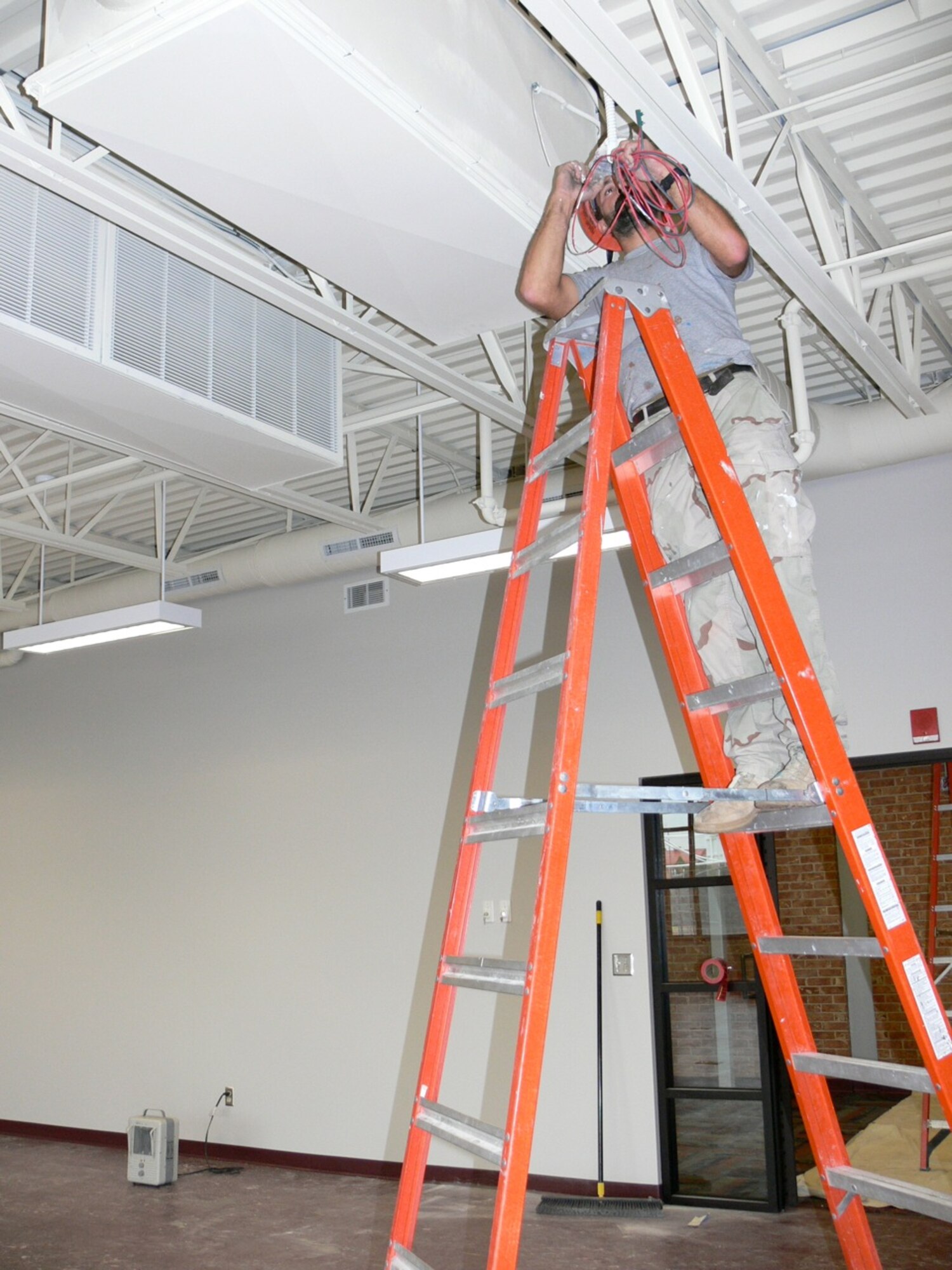 Contractor Stephan Morin puts final touches on the ceiling of the new cardio room in the Peterson Sports and Fitness Center, which is expected to open in mid-December. The cardio room will feature 30 machines, including treadmills and Arc trainers, which are low-impact machines that combine elements of climbing, hiking and skiing. (U.S. Air Force photo/Monica Mendoza)