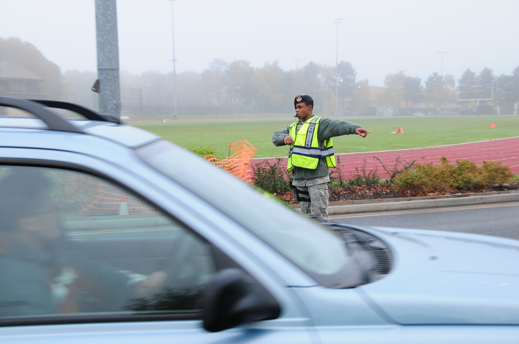 ROYAL AIR FORCE LAKENHEATH, England – Senior Airman Kentavius Morton, 48th Security Force Squadron, directs traffic away from the 2010 Turkey Trot course, which went from the fitness center to the golf course and back, on Nov. 20. Airmen from the 48th SFS and event volunteers ensured the runners’ safety by directing traffic away from the running route.  (U.S. Air Force photo/Senior Airman Stephen Linch)