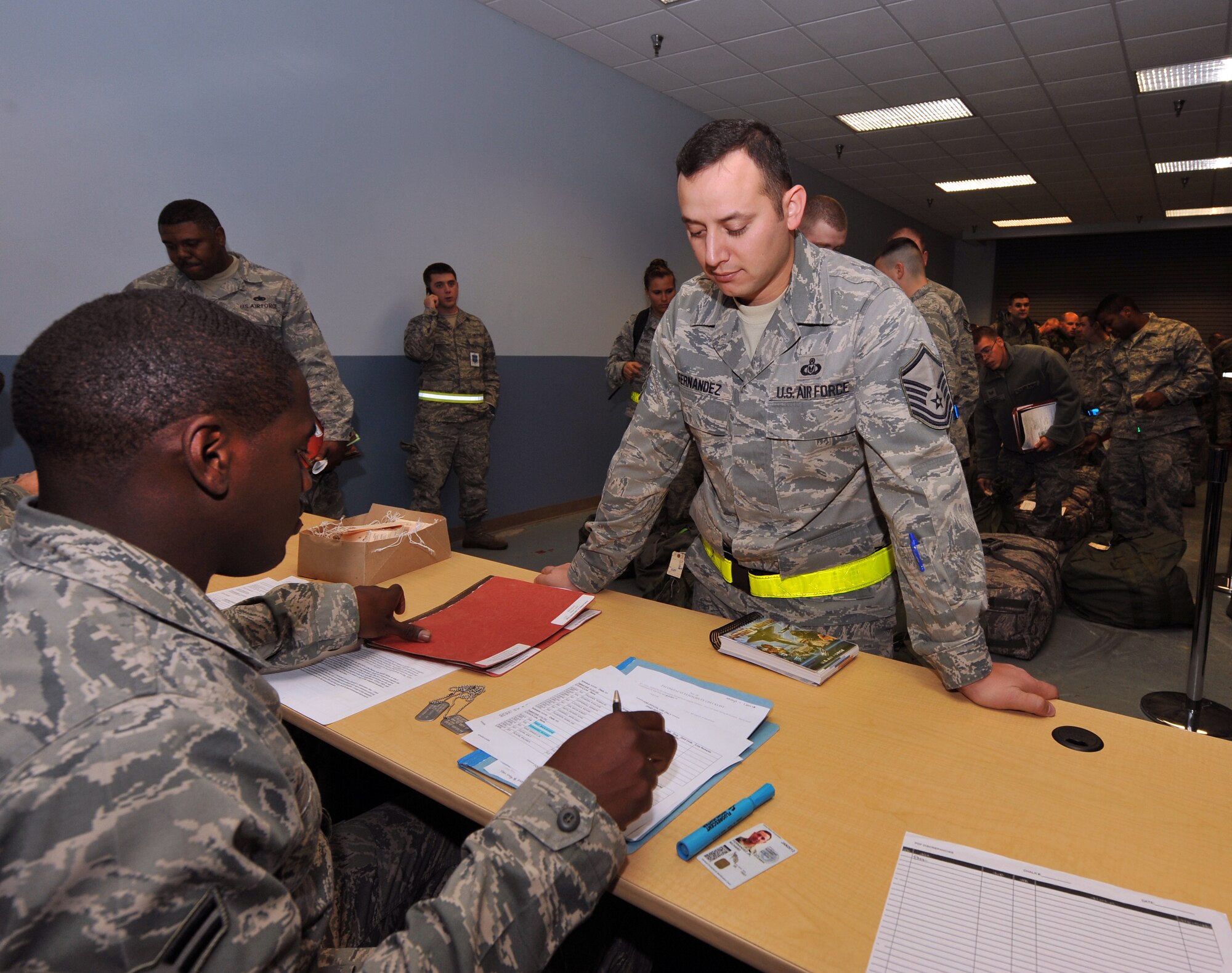 Airman 1st Class Zachary White, a 19th Force Support Squadron customer service specialist, checks Master Sgt. Richard Fernandez, 19th Operation Support Squadron aircrew flight equipment section chief, pre-deployment folder during the processing line Nov. 16, 2010, at Little Rock Air Force Base, Ark.  The Operation Readiness Exercise was conducted to test and prepare Little Rock Airmen for future deployments and be mission ready. (U.S. Air Force photo by Senior Airman Gul Crockett)