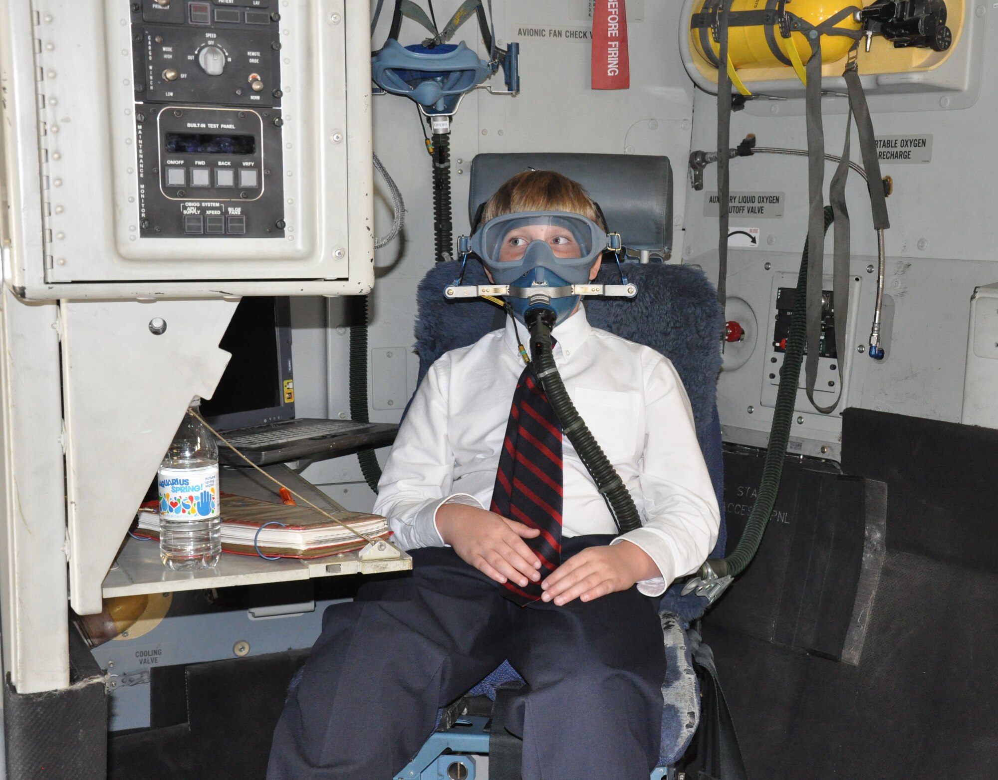A student from The Charleston Catholic School sits in the loadmaster's seat and dons an oxygen mask  during a static tour of a C-17 Globemaster III aircraft during their visit to Joint Base Charleston, S.C. Nov. 19, 2010. (U.S. Air Force photo/Airman 1st Class Robert Pilch)