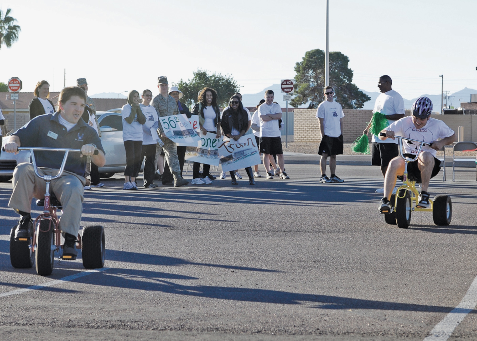 Kevin Bruaw, 56th Force Support Squadron sports specialist, and Airman 1st Class Jeremy McCalmon, 56th Component Maintenance Squadron Egress Systems apprentice, race on tricycles while people watched on November 12th during the Wacky Olympics held at Luke Air Force Base, Arizona.  (U.S. Air Force photo/Staff Sgt. Louis Vega Jr.)