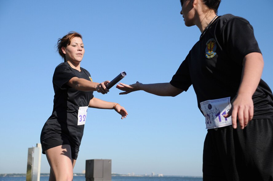 MacDill Air Force Base, Fla. --  Braving chilly morning temperatures, Senior Airman Ashley Blasen, a  Knowledge Operations Management Journeyman with Special Operations Command here, passes the baton to her partner in the 30th George G. Mattar Relay Race.  The Plain Dealing, La. native joined members of 33 teams, each of which completed the 13-mile relay race to commemorate Col. George Mattar and others who perished in a plane crash in 1982.   (Official United States Air Force photo by Staff Sgt. Shawn C. Rhodes)