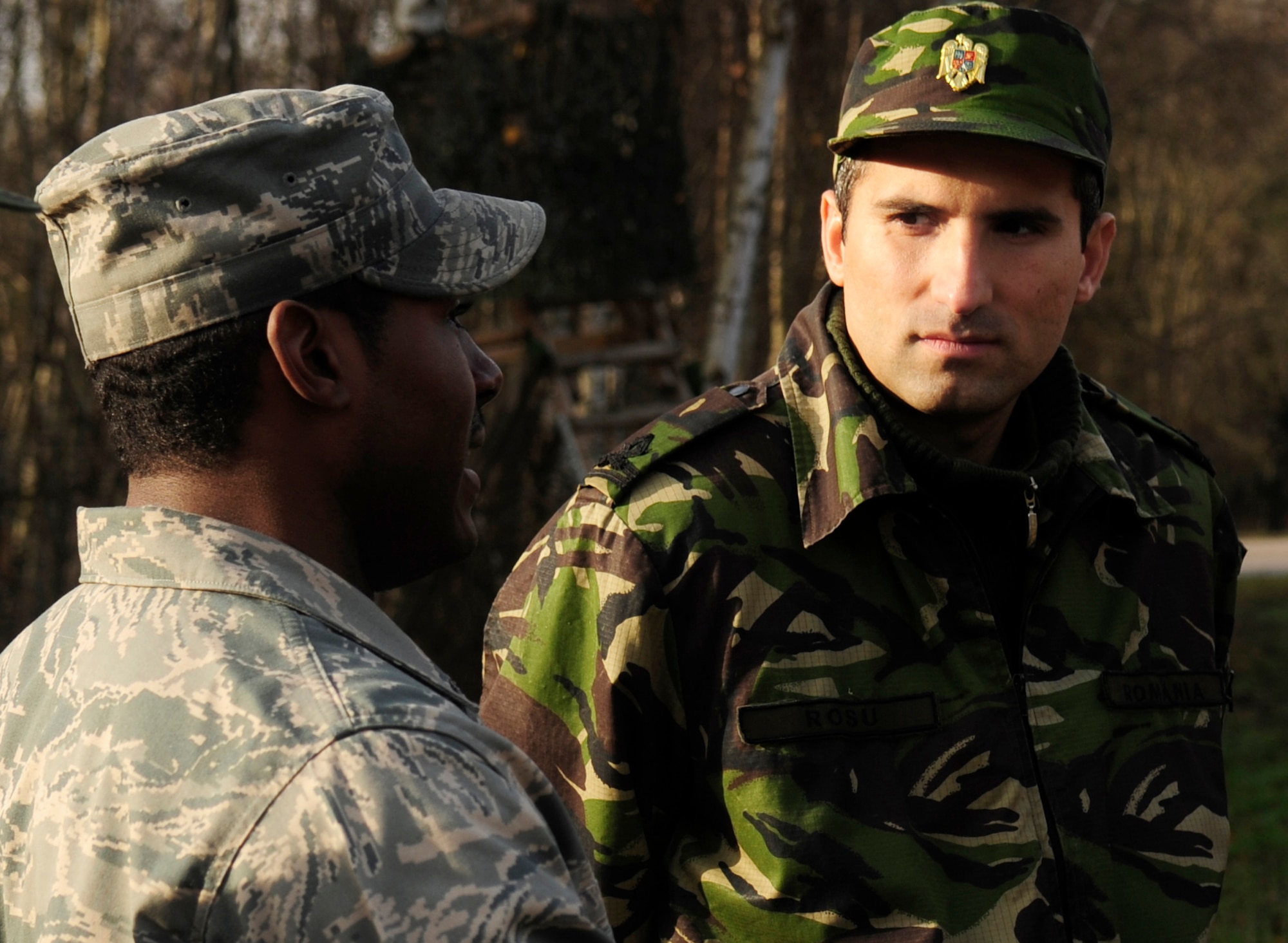 U.S. Air Force Master Sgt. Lamont Hall, a Silver Flag Cadre, explains to Romanian air force 2nd  Lt. Octavian Rosu, the practical exercise being carried out by U.S. Air Force Airmen, during Silver Flag, Ramstein Air Base, Germany, Nov. 20, 2010. Silver flag is a weeklong, ongoing training program that combines classroom and practical application exercises to prepare Airmen for deployment scenarios. Members of the Romanian air force were invited to observe training and share information, to develop integrated solutions, so that they can take the information back and implement some of the same principals to their own forces' training.  (U.S. Air Force Photo by Tech Sgt. Jocelyn Rich)