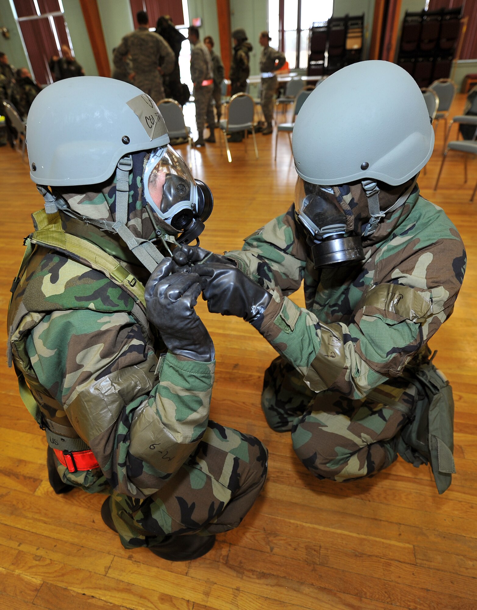 Maj. Daniel Barrows, 19th Airlift Wing executive officer, and Col. Michael Zick, 19th Airlift Wing vice commander, perform buddy checks on each other's J-list chemical suits Nov. 18, 2010, during the RockEx at Little Rock Air Force Base, Ark. Members of the 19th Airlift Wing are preparing for the upcoming Operational Readiness Inspection by honing their skills with a base Operation’s Readiness Exercise. (U.S. Air Force photo by Staff Sgt. Chris Willis)