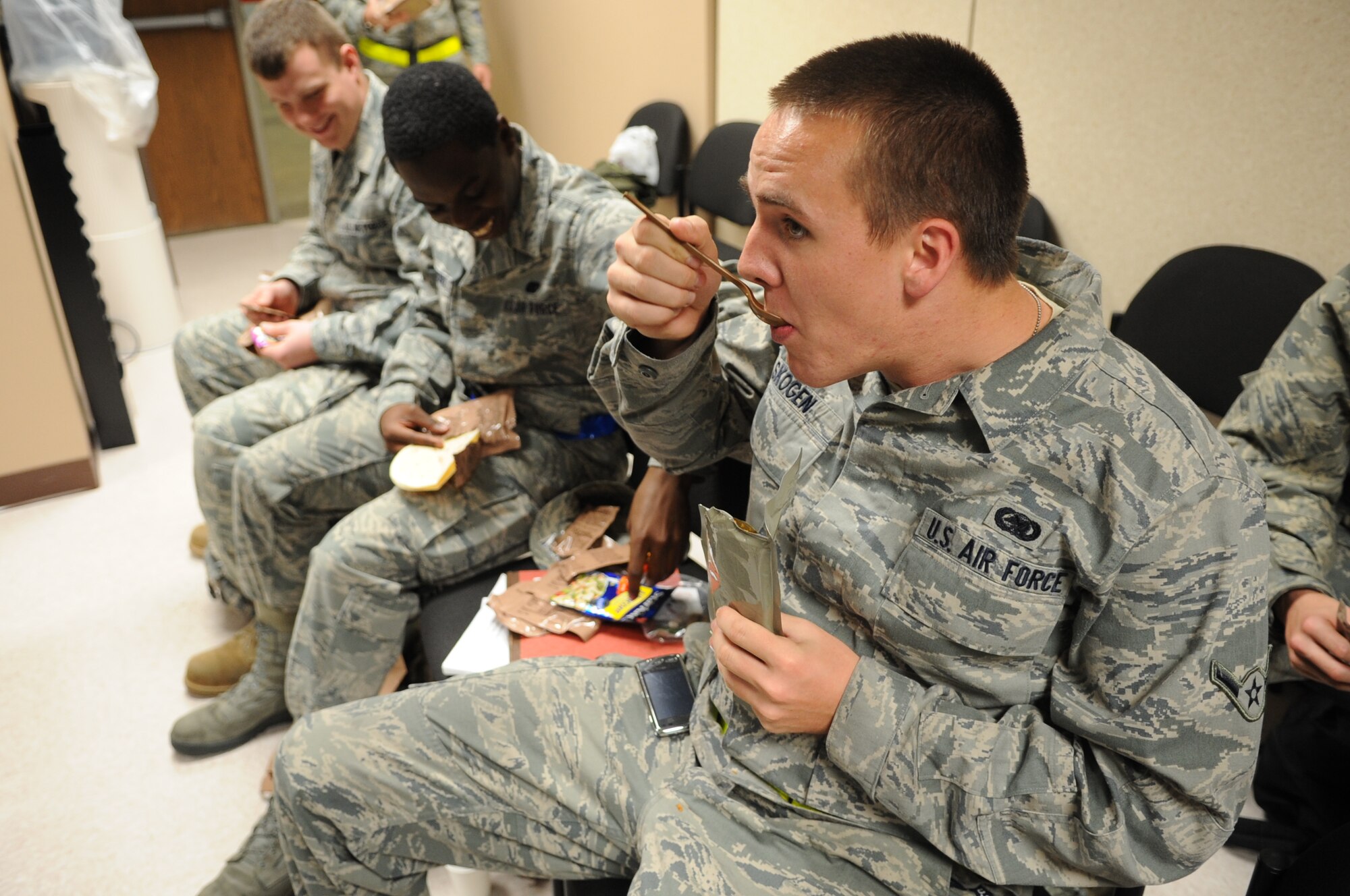 Airman Adam Skogen, 19th Logistics Readiness Squadron, along with other base exercises players, enjoys a Meals-Ready-to-Eat Nov. 16, 2010, at Little Rock Air Force Base, Ark. Several members ate the MRE's while waiting for the aircraft to Camp Warlord where they practiced for the upcoming Operational Readiness Inspection by “deploying” to a simulated deployed location. (U.S. Air Force photo by Staff Sgt. Chris Willis)