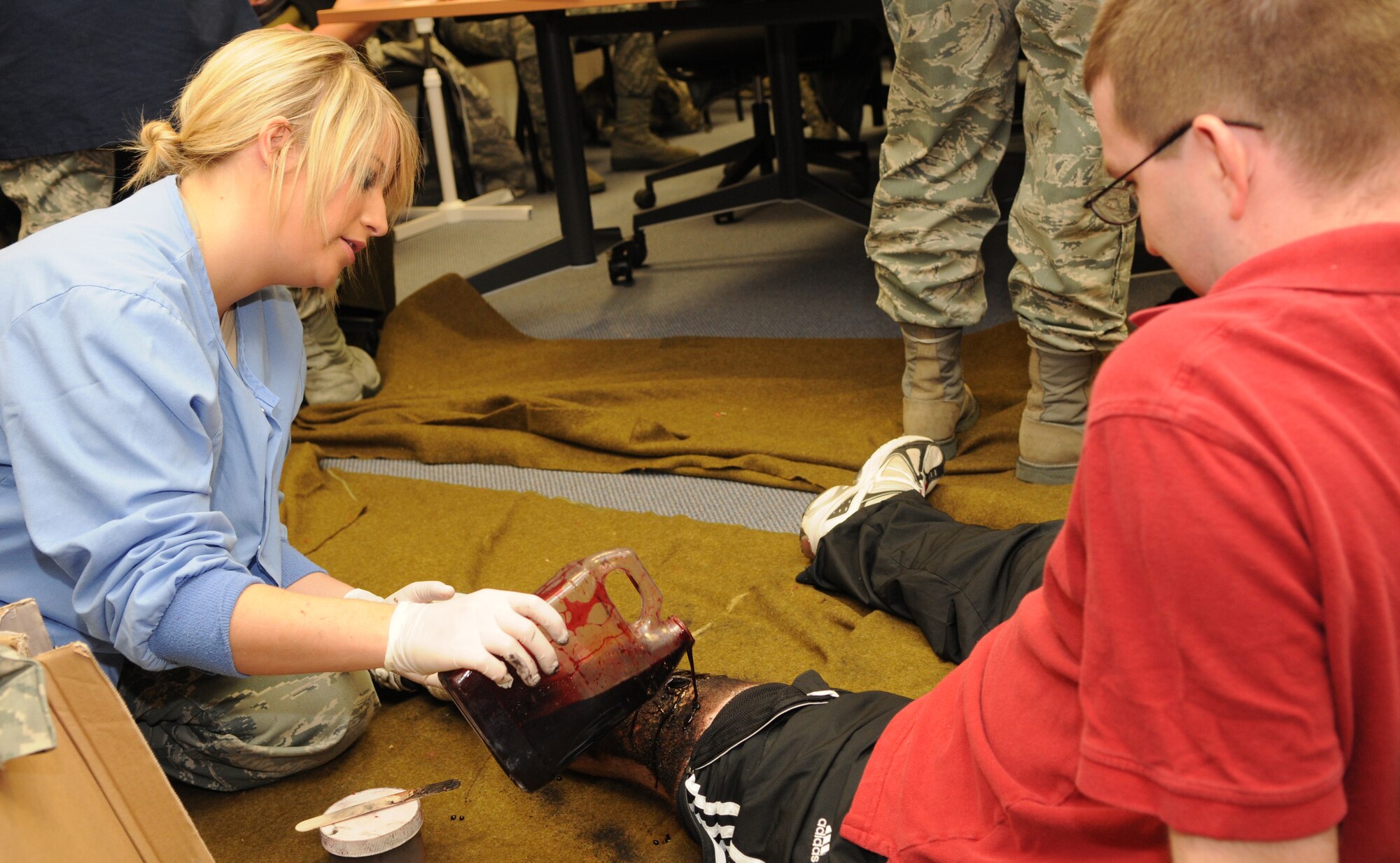 SPANGDAHLEM AIR BASE, Germany – Airman 1st Class Christa Miller, 52nd Dental Squadron, applies fake blood from a moulage kit onto the leg of Staff Sgt. Kevin Kelly, 52nd Medical Operations Squadron, in preparation for an emergency response exercise Nov. 16. The exercise evaluated the Wing’s response to an incident including hazardous chemical exposure. (U.S. Air Force photo/Airman 1st Class Matthew B. Fredericks)