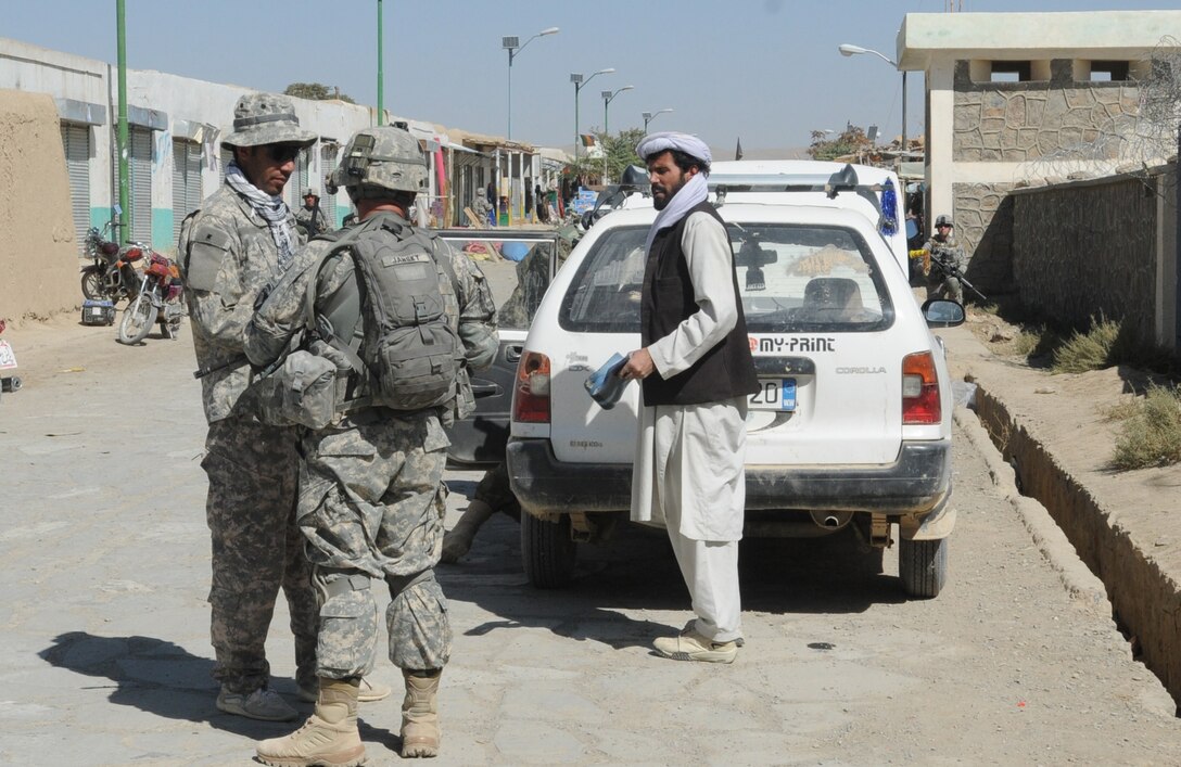 U.S. Army Sgt. David Jansky, squad leader and company counterinsurgency team member of 3rd Squad, 3rd Platoon, Company C, 1st Battalion of the 506th Infantry Regiment, 4th Brigade Combat Team, 101st Airborne Division, talks with a resident of the city of Khayr-Khot Castle, Afghanistan, while Afghan National Army soldiers search his vehicle Oct. 6, 2010. The soldiers conduct after-action reviews following every patrol to identify what went right and what can be done more effectively. U.S. Army photo by Spc. Luther Booth Jr.