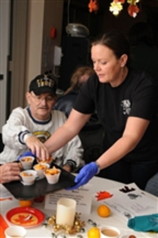 U.S. Navy Chief Petty Officer Katie Cruz, assigned to Navy Recruiting District Seattle, serves food to Army veteran Tony Beck at the VA Medical Center in Seattle, Wash., during a Thanksgiving dinner for veterans and their family members on Nov. 17, 2010.  
