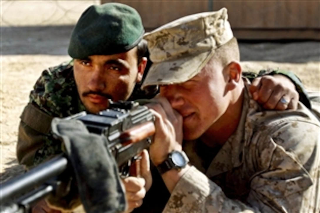 Mohammad Zaman, an Afghan soldier, serves as a spotter as U.S. Marine Corps Cpl. Phillip Sever sits in during a weapons class on Camp Leatherneck, Afghanistan, Nov. 21, 2010.  Sever, a Headquarters & Service Company mentor, is assigned to Combat Logistics Battalion 3, 1st Marine Logistics Group. Marines from the group are training Afghan soldiers to help them operate independently.