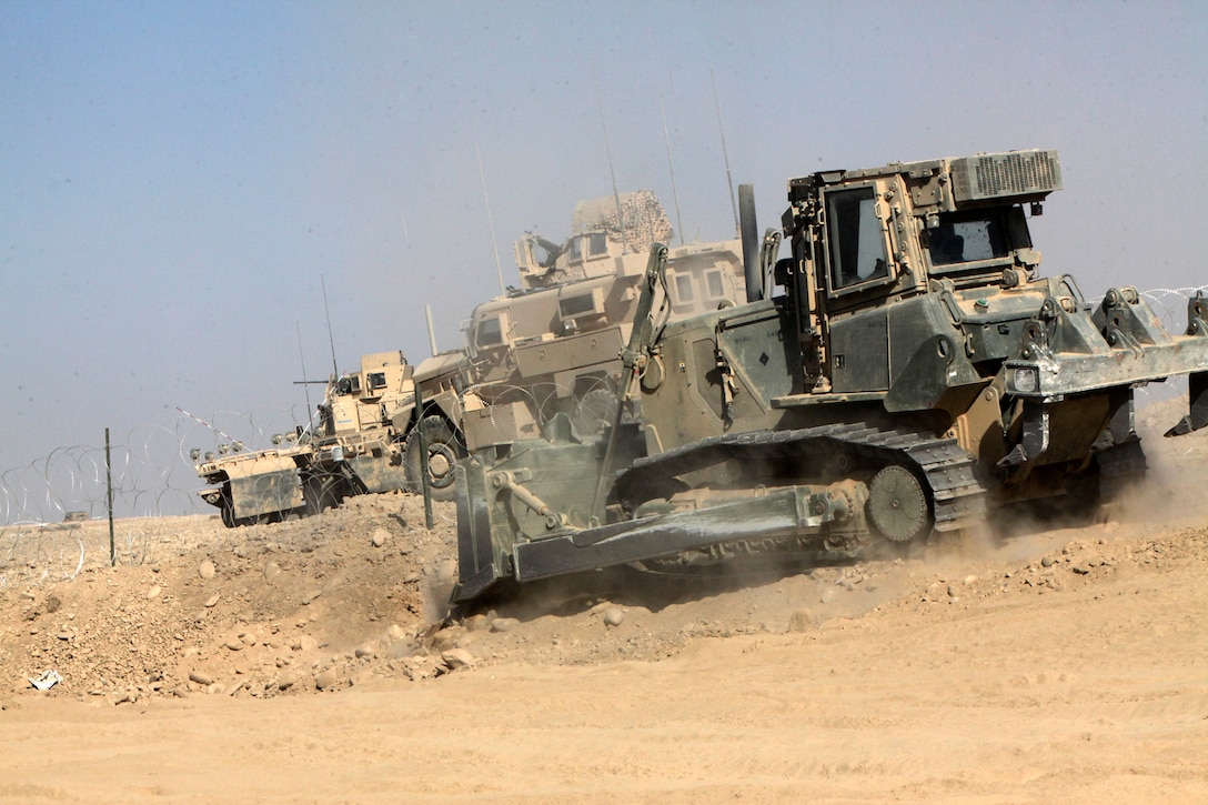 Lance Cpl. Bradley D. Bonee, a heavy equipment operator with 1st Platoon, Charlie Company, Combat Logistics Battalion 2, 1st Marine Logistics Group (Forward), builds a berm while improving Forward Operating Base Robinson in Helmand province, Afghanistan, Nov 22.  In addition to helping engineers build and improve forward operating bases throughout Helmand province, heavy equipment Marines also transport thousands of pounds of cargo needed to sustain warfighters on the frontlines.