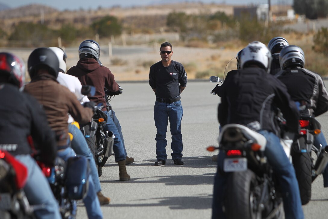 Frank Santiago [standing], a motorcycle safety instructor aboard the Combat Center, delivers one of many safety lessons to his students in the Basic Riders Course Tuesday here. Along with BRC, Marines and sailors receive information from safety briefs and other inputs to keep them knowledgeable and safe throughout the holidays. ::r::::n::