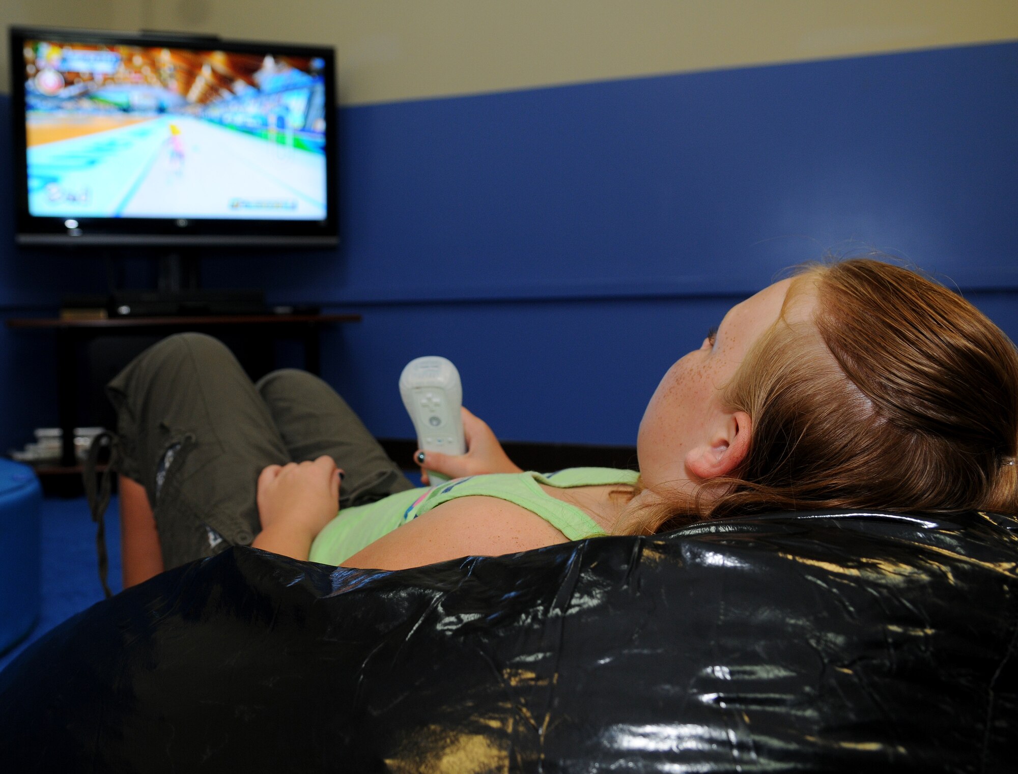 Madison Guinzy plays a game on Nintendo wii during the grand opening celebration for the Community Center at Andersen Air Force Base, Guam, Nov. 19. The Community Center is open to all of Team Andersen family. It has computers with internet access, wifi, gaming consoles, televisions a blu-ray player and a variety of activities for children. (U.S. Air Force photo/Senior Airman Nichelle Anderson) 