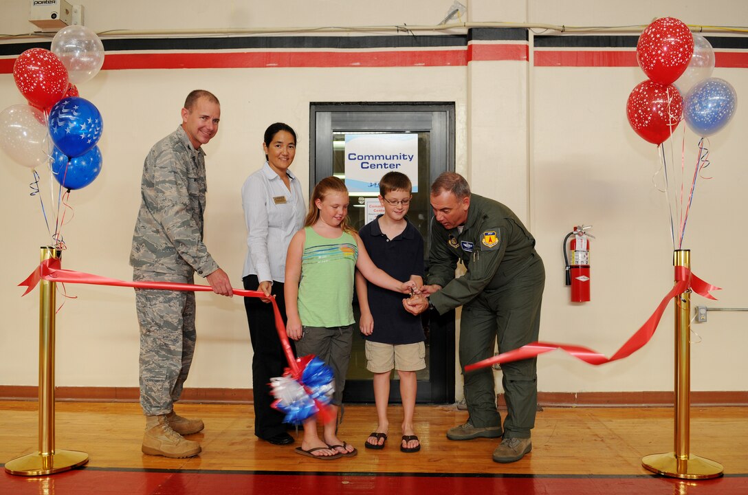 Brig. Gen. John Doucette, 36th Wing commander, Col. Alan Weider, 36th Mission Support Group commander, Ms. Michele Jacobs, 36th Force Support Squadron, Hotspot/Community  Activates director, Madison and Asher Guinzy cut the ribbon signifying the Grand Opening of the Community Center here, Nov. 19. (U.S. Air Force photo/Senior Airman Nichelle Anderson)