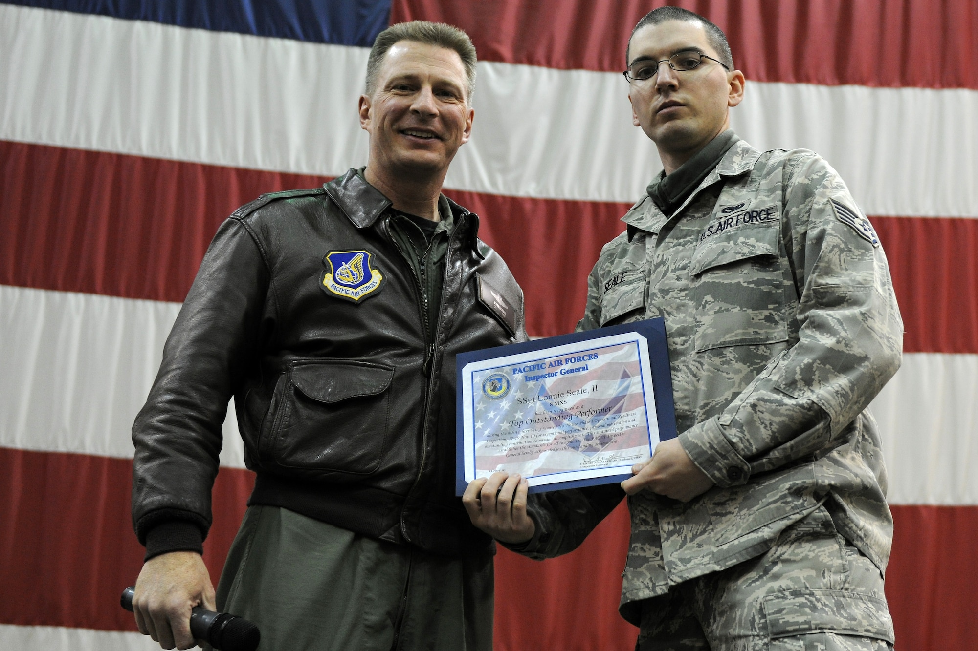 KUNSAN AIR BASE, Republic of Korea -- Col. John Dolan, 8th Fighter Wing commander, presents Staff Sgt. Lonnie Seale, 8th Maintenance Squadron, with a commanders coin for being recognized as an outstanding performer during a no notice readiness inspection during a commanders call Nov. 23.  The wing participated in the Phase 1 operational readiness inspection Beverly Bearcat 10-06 that tested the wing's prepartion and mobilization from peacetime readiness into wartime posture. (U.S. Air Force photo/Staff Sgt. Jonathan Pomeroy)
