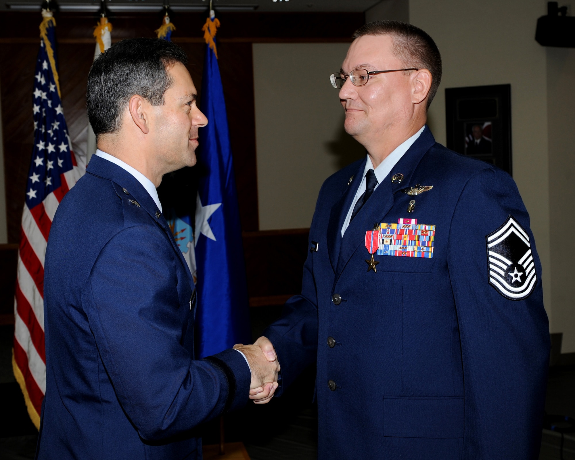 Brig. Gen. Ken Wilsbach, 18th Wing commander, presents the Bronze Star Medal to Senior Master Sgt. Patrick McEneany, 18th Medical Operations Squadron, during a ceremony Nov. 24 at the Kadena Clinic. Sergeant McEneany was an independent duty medical technician for a joint task force in support of operation Iraqi Freedom working with the Air Force and United States Army. (U.S. Air Force photo/Junko Kinjo)